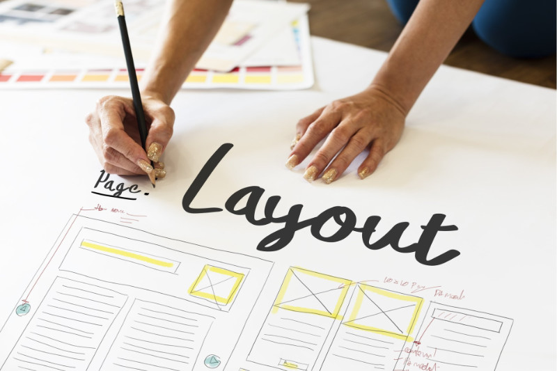 A person drawing a layout of a website on a piece of paper.